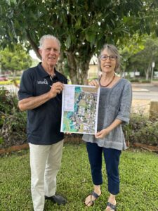 The Mayor and Tablelands Community Housing Manager Marita Romano holding plans in front of a tree at Tablelands Regional Council's offices in Atherton.