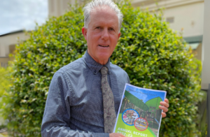 Mayor Rod Marti holding a copy of Tablelands Regional Council's Annual Report.